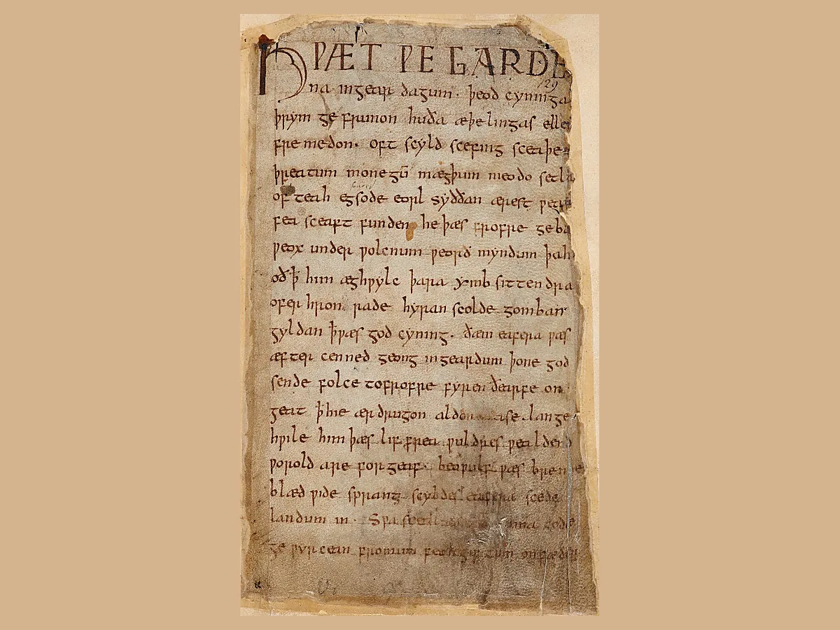 Opening page of the Beowulf manuscript, written in Old English around AD 1000, showing Anglo-Saxon handwriting on aged parchment.